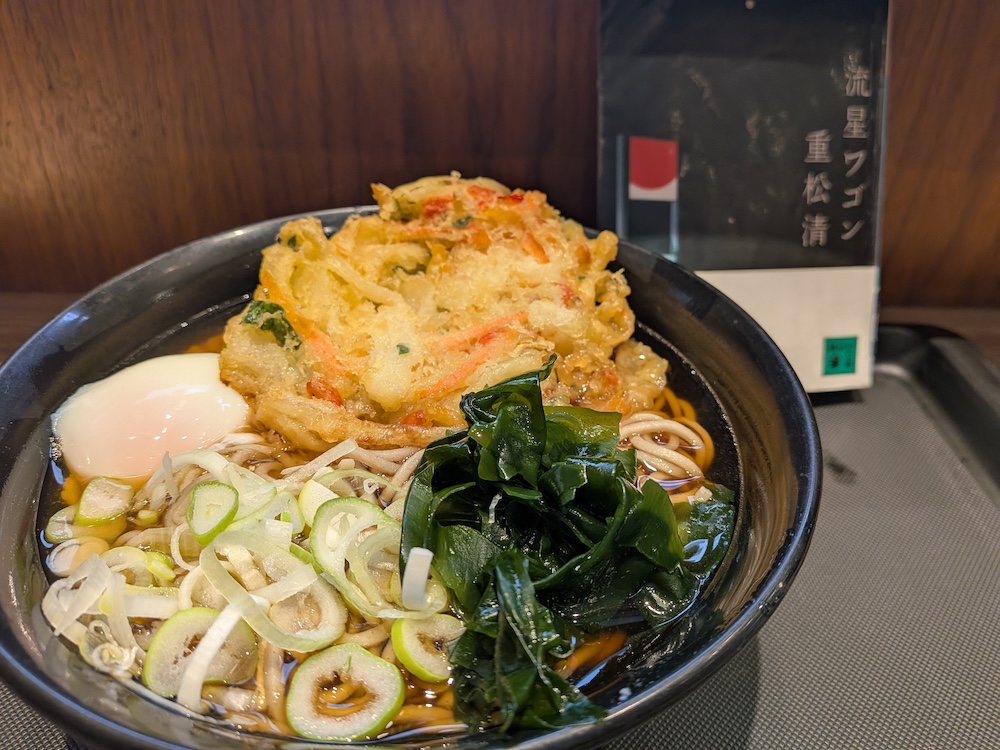 富士そば「かき揚げそば(温玉トッピング)」と背景に読みかけの本「流星ワゴン」