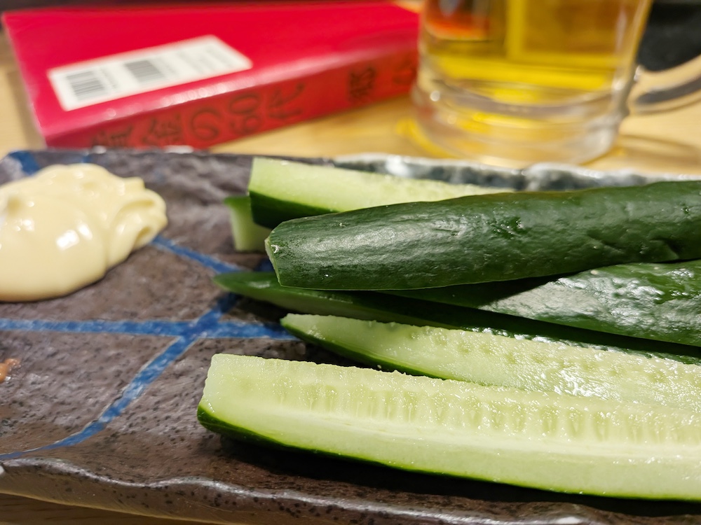 もろきゅうの後ろに読みかけの本「黄金の60代」とビール