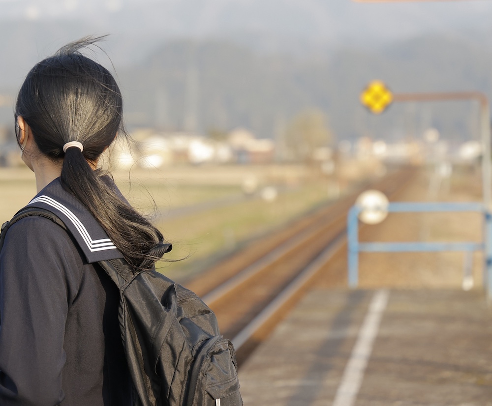 駅で電車を松女子高生［版権フリー素材］
