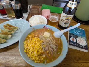 くるまやラーメン 味噌バターラーメン、餃子、半ライス、キリン一番絞り（瓶）と読みかけの本（オオルリ流星群）