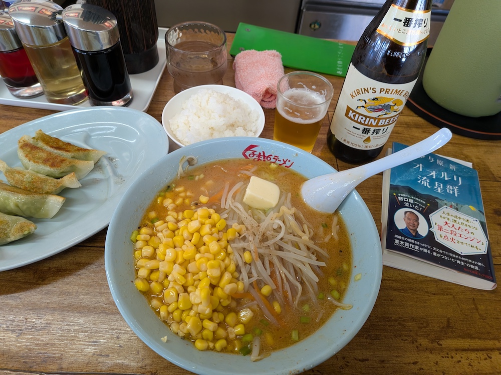 くるまやラーメン 味噌バターラーメン、餃子、半ライス、キリン一番絞り（瓶）と読みかけの本（オオルリ流星群）